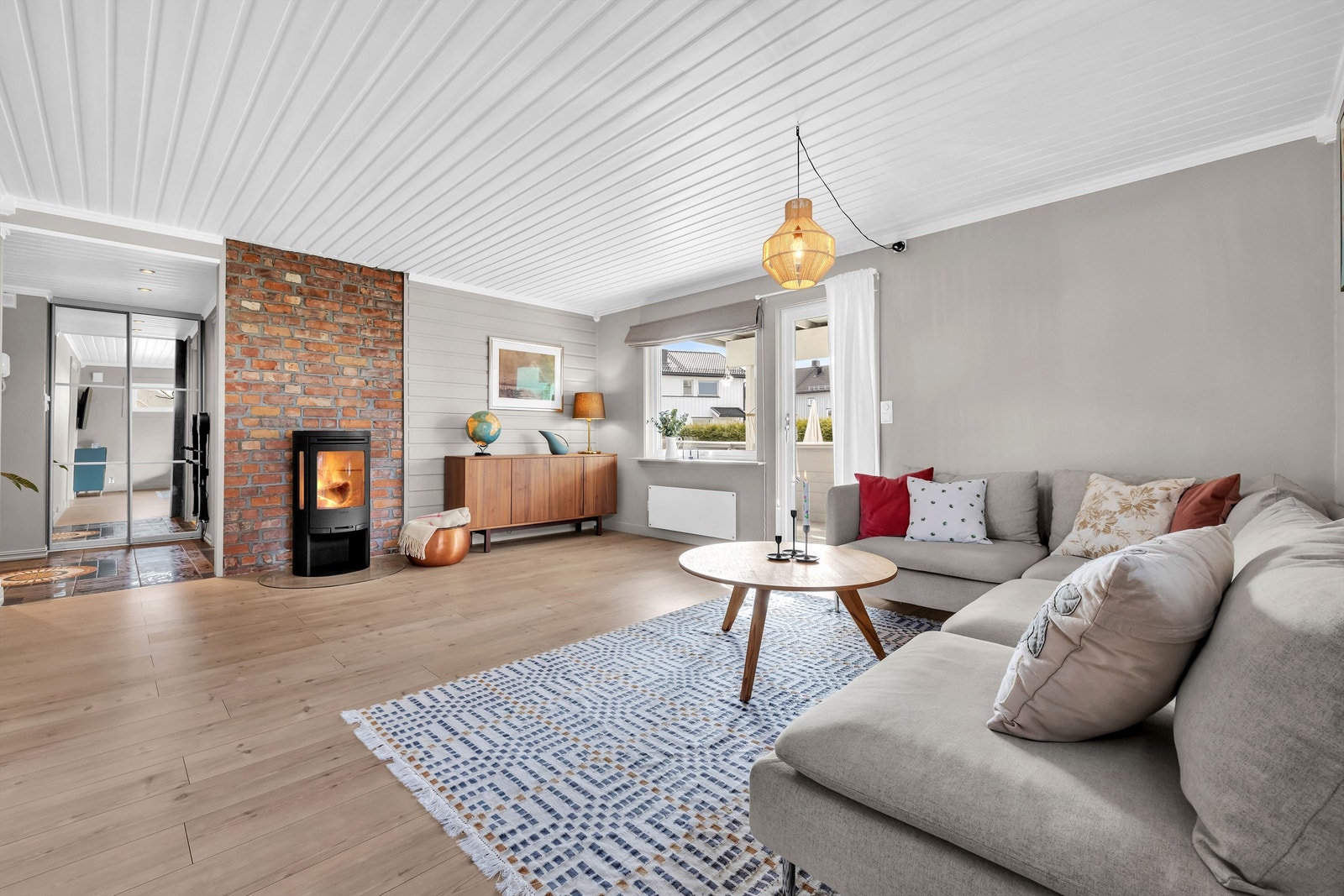 Stuen har en koselig teglsteinsvegg og peis! Galleribilde