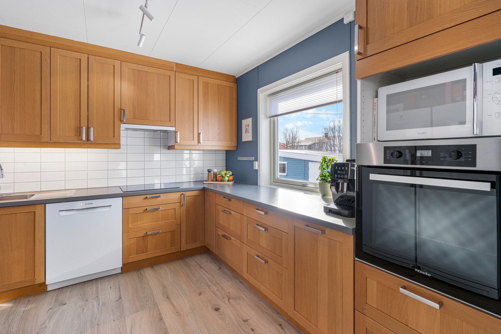 Kjøkkenet har integrerte hvitevarer som steiketopp og komfyr Galleribilde