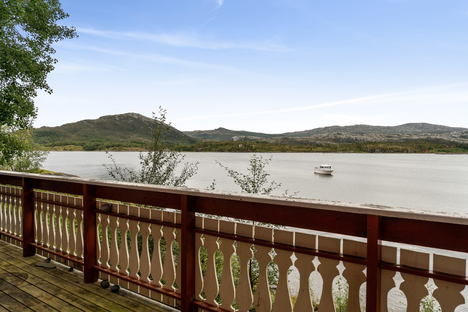 Det finnes trapper på begge sider av verandaen for å komme seg ned til bakken Galleribilde