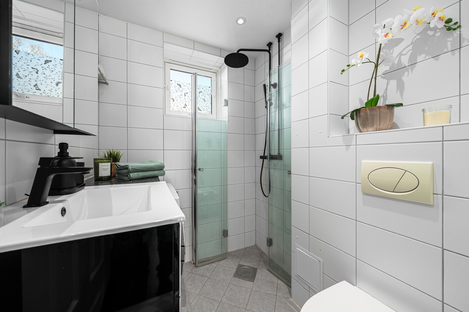 Baderomsinnredningen består av sorte og hvite detaljer samt et speilskap Galleribilde