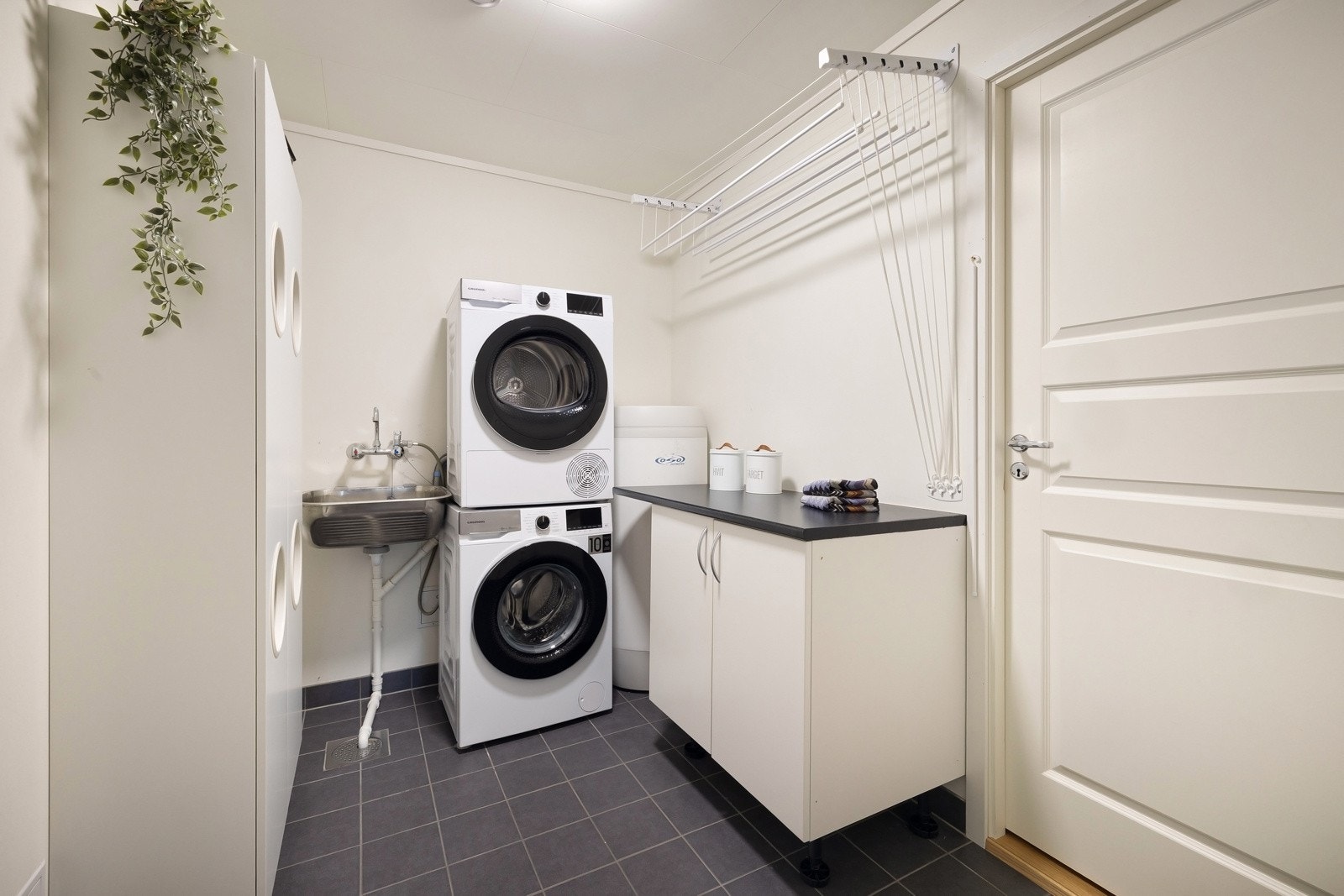 På vaskerommet står varmtvannsberederen og vannskap. Her er også utslagsvask og opplegg for vaskemaskin ig tørketrommel. Galleribilde