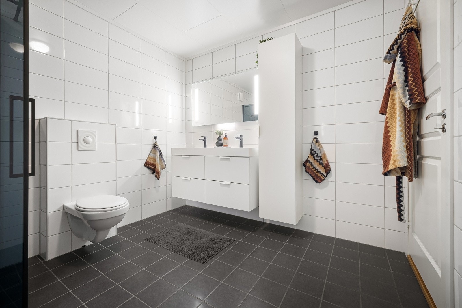 Badet er helfliset med lyse og tidløse fliser på veggene, og mørke fliser på gulvet. I gulvet er det elektriske varmekabler. Galleribilde