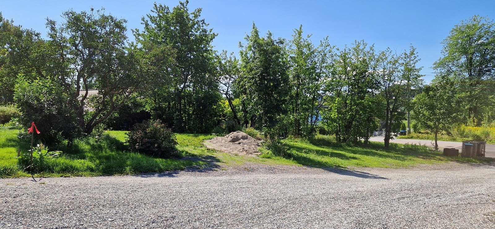 Tomtegrense mellom vimpel og søppelstativ. Galleribilde