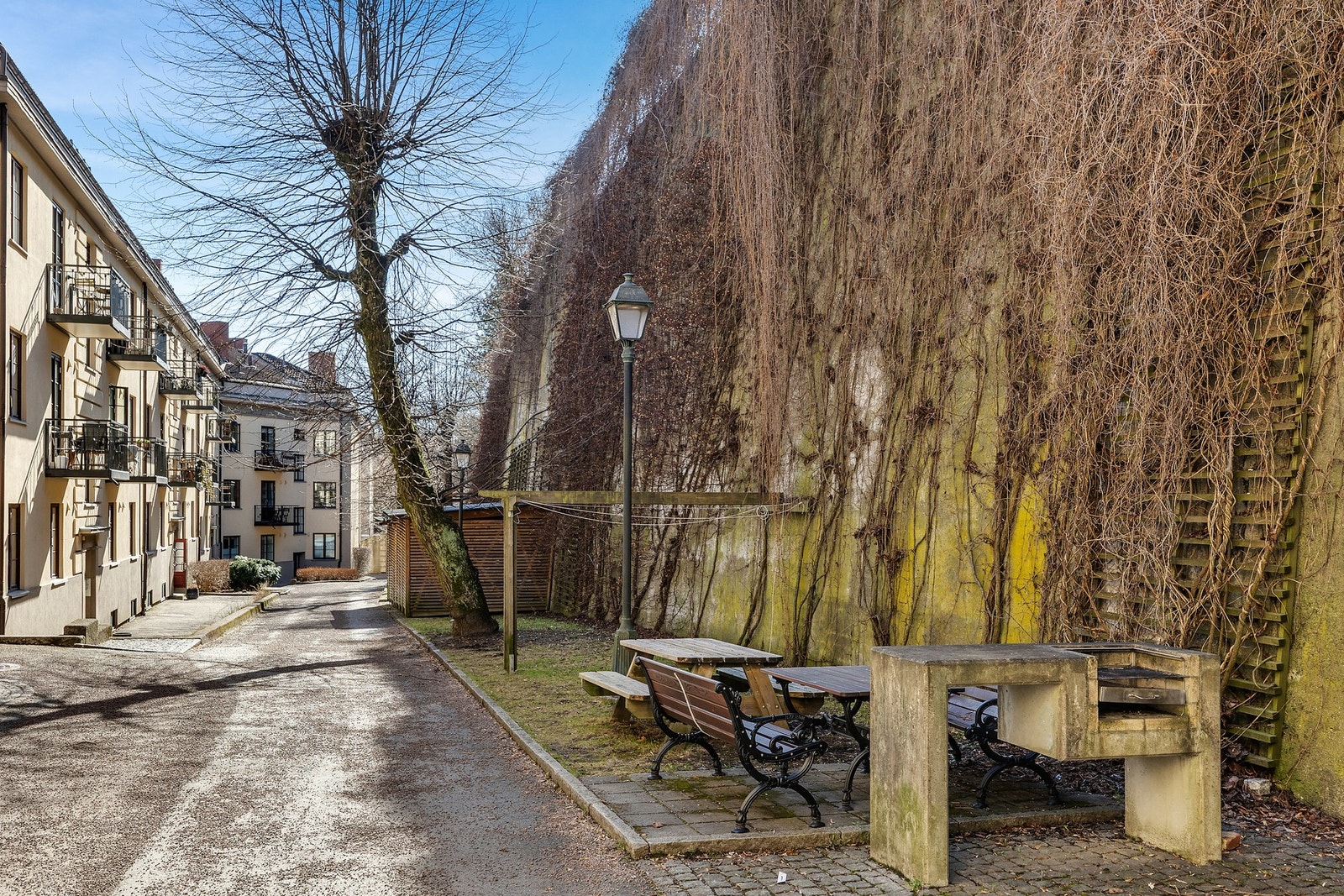 Sjarmerende bakgård med felles sittegruppe og grill - perfekt for varme sommerkvelder eller en rolig kaffestund i solen Galleribilde