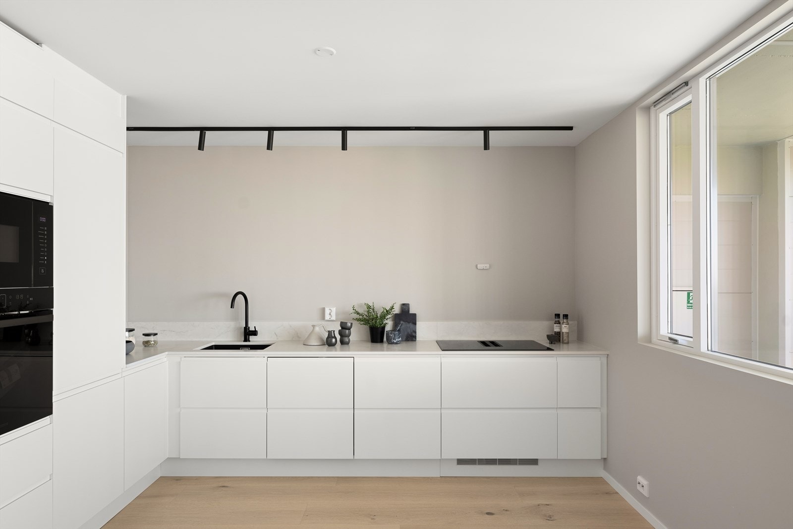 Kjøkkenet ligger i delvis åpen løsning mot stuen og har hvite, matte fronter som gir et rent og skandinavisk uttrykk. Galleribilde