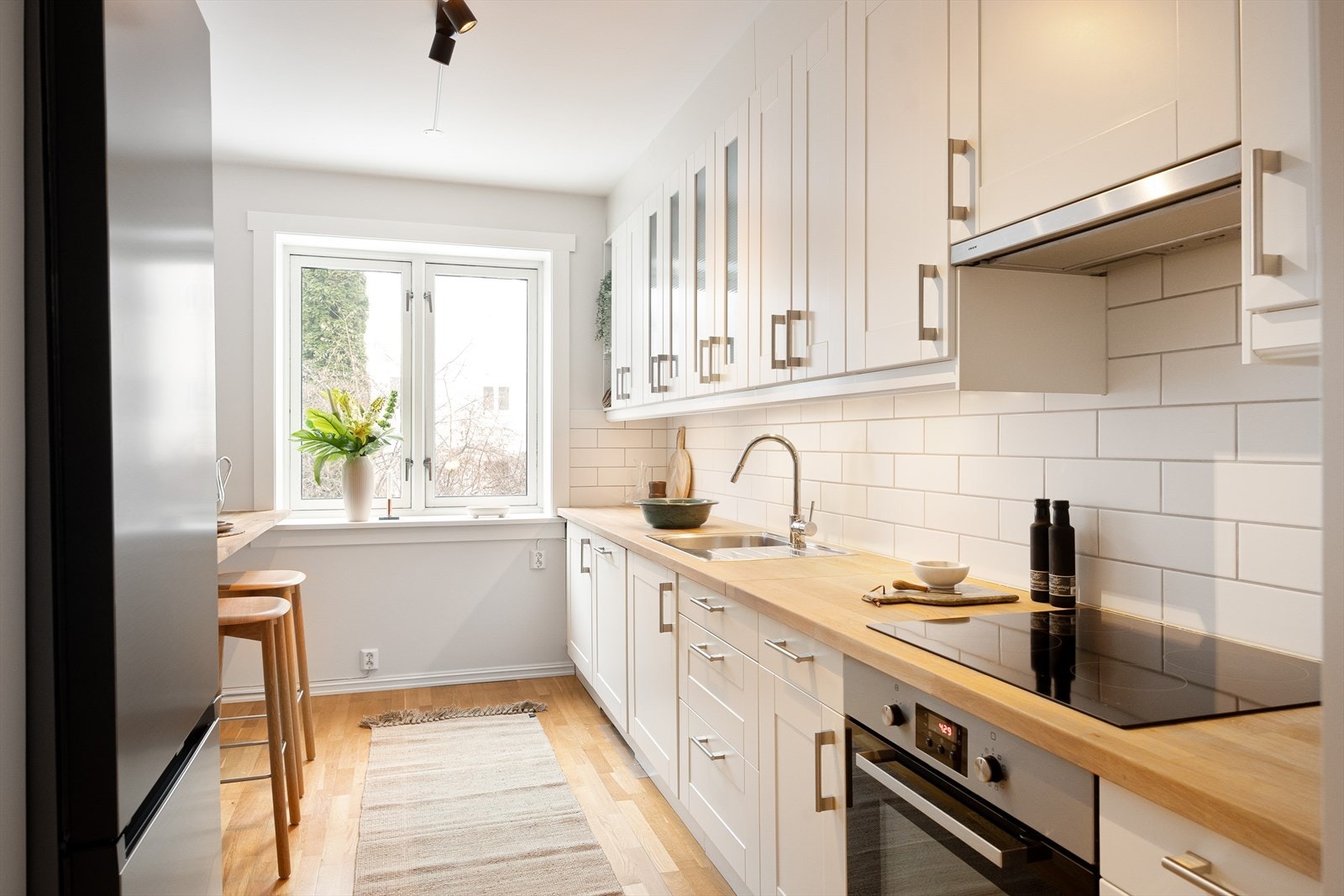 Moderne kjøkken med rikelig skap- og benkeplass. De profilerte frontene gir et klassisk preg, mens benkeplaten i heltre tilfører varme og kvalitet. Galleribilde