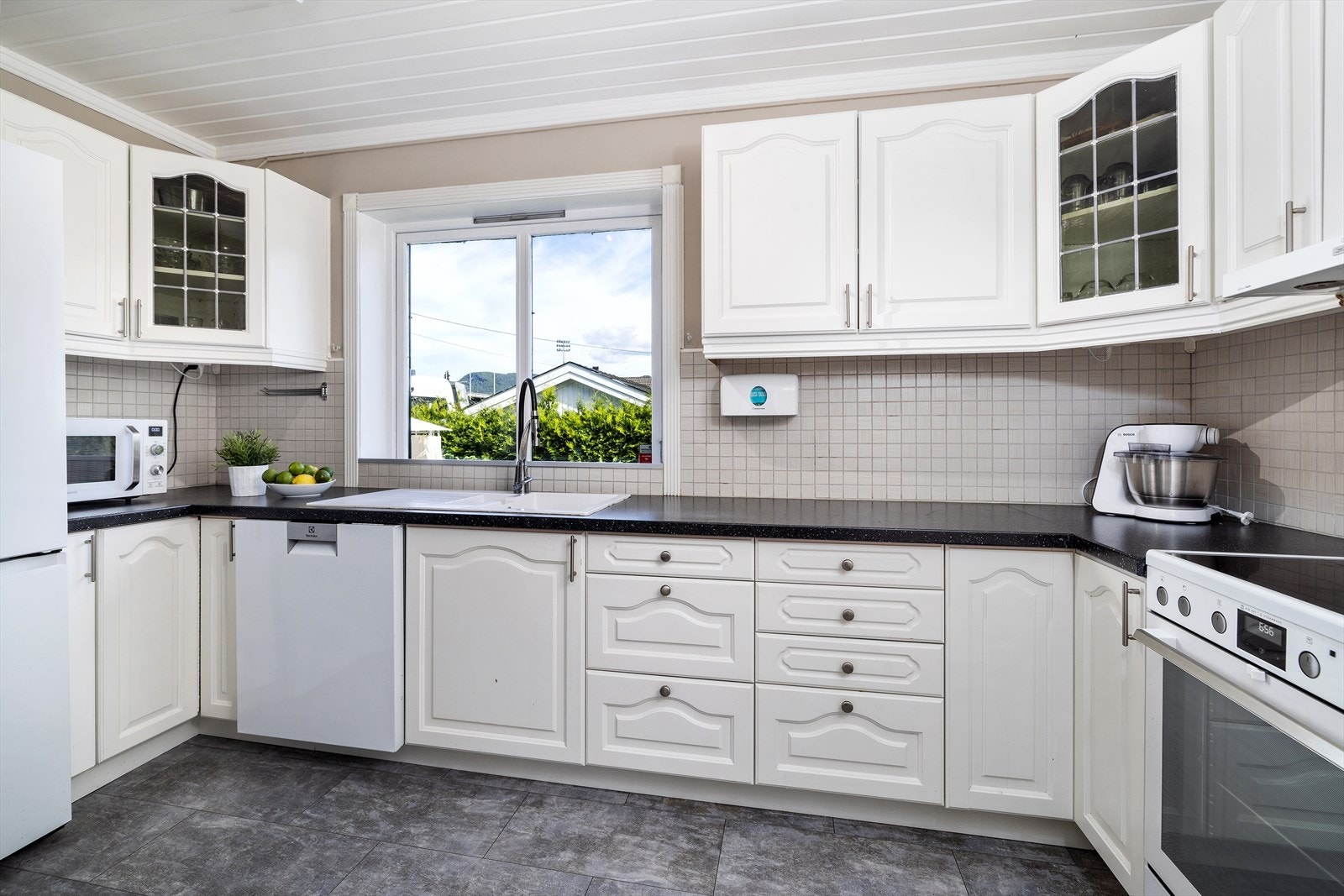 Innredningen har lyse, profilerte fronter og laminat benkeplate. Galleribilde