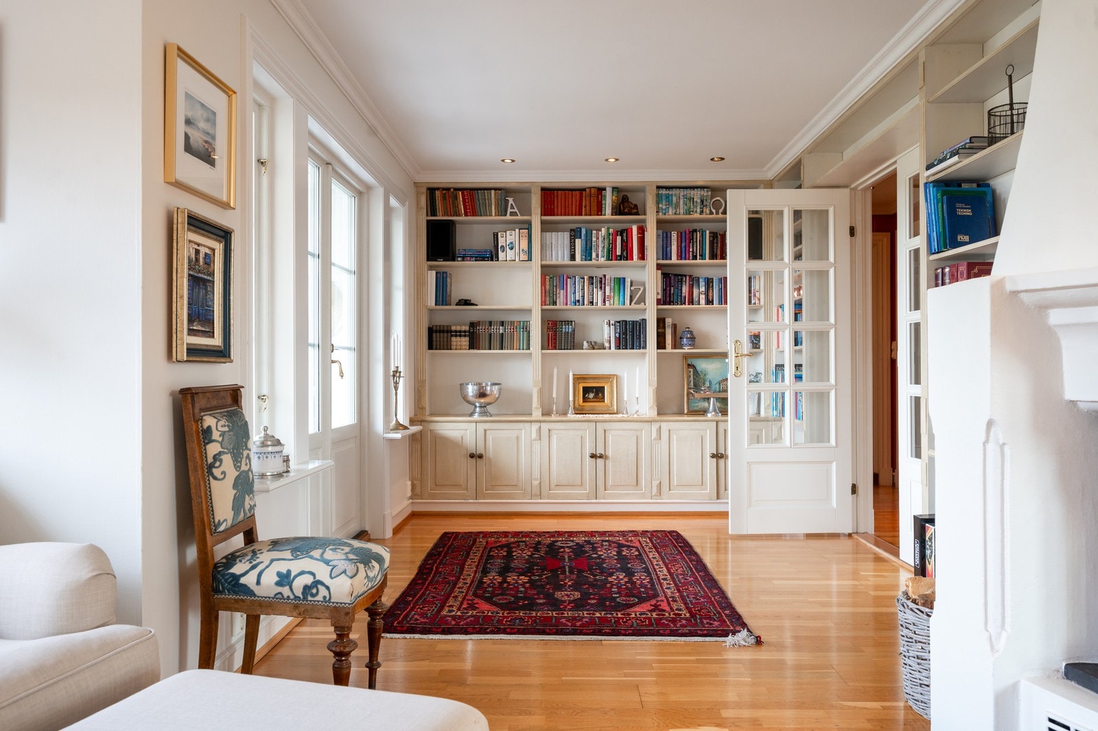 Bibliotek-stue med utgang til usjernert markterrasse og hage Galleribilde