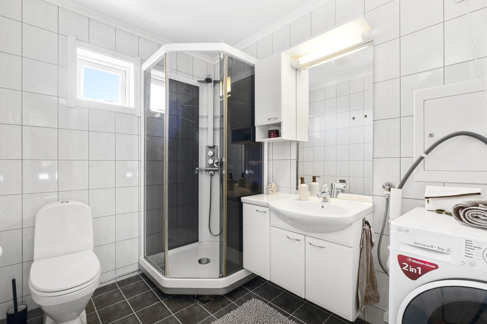 Badet har lyse fliser og varmekabler i gulvet, som gir en komfortabel og praktisk løsning for hverdagen Galleribilde