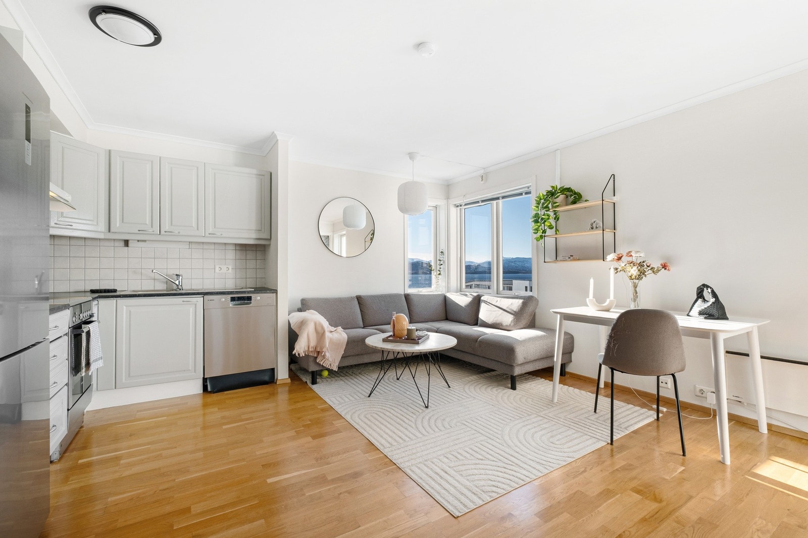 Lys og luftig stue med store vinduer som slipper inn rikelig med dagslys Galleribilde