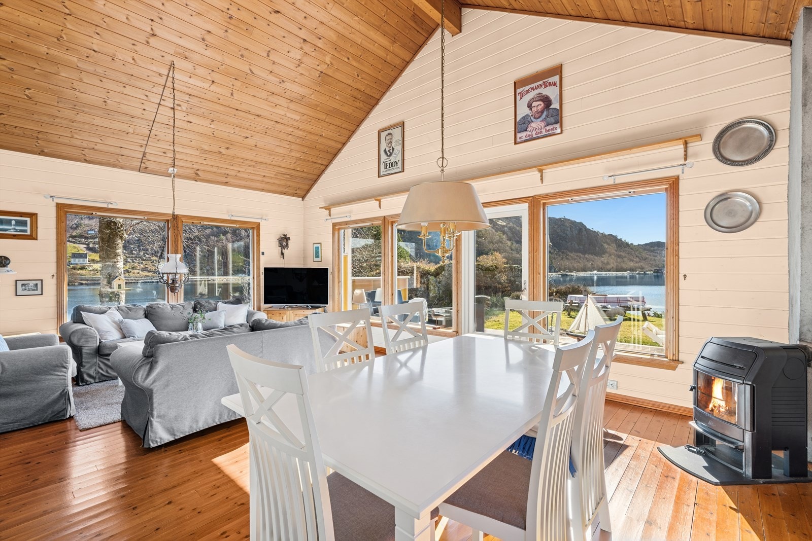 En gjennomgående fritidsbolig med utstrakt bruk av furubord på gulv, lysmalt panel på vegger og panel i tak. Galleribilde