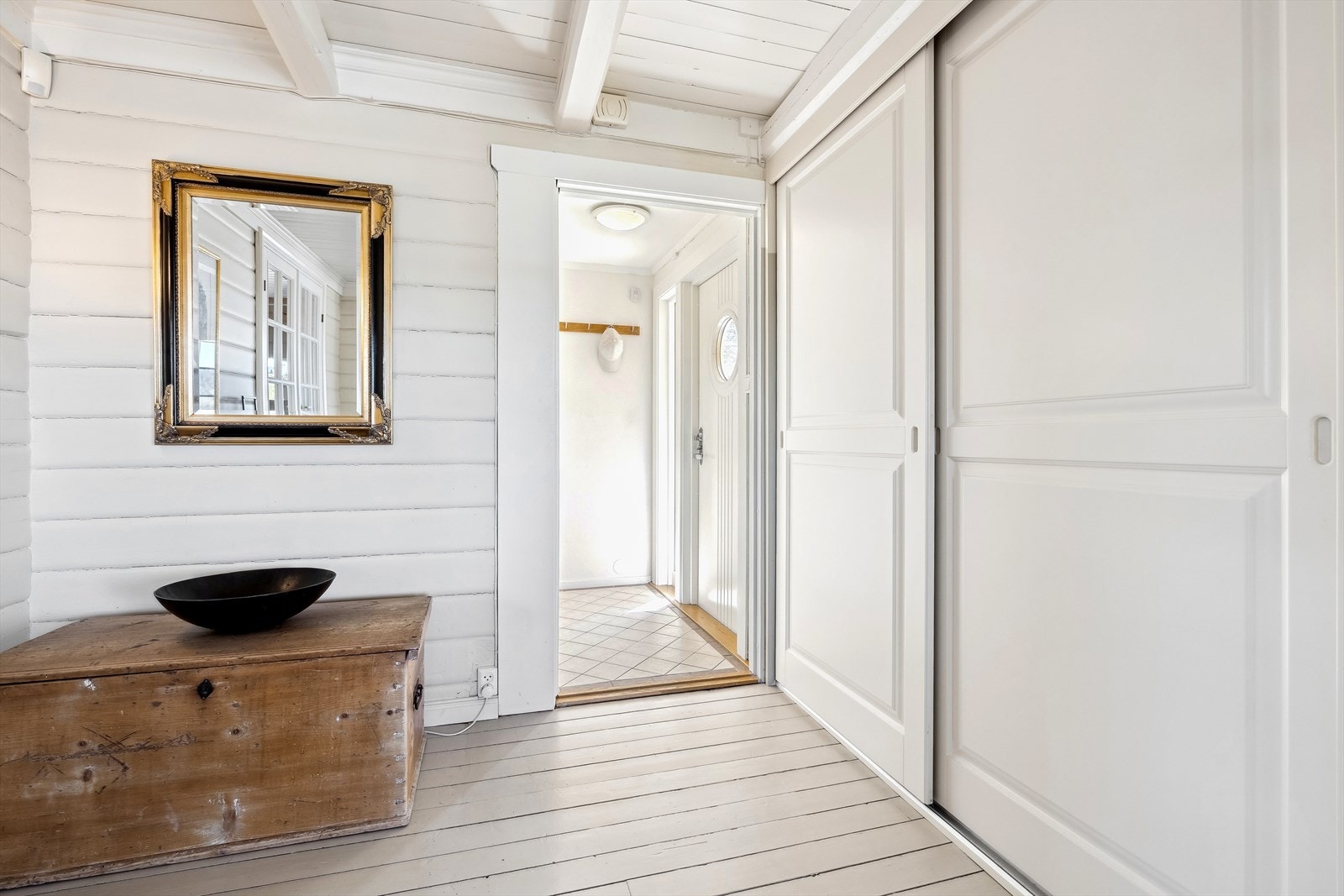 Trivelig entré som ønsker deg velkommen hjem, med plass til å henge fra seg yttertøy og sette fra seg sko i en praktisk skyvedørsgarderobe i gangen. Galleribilde