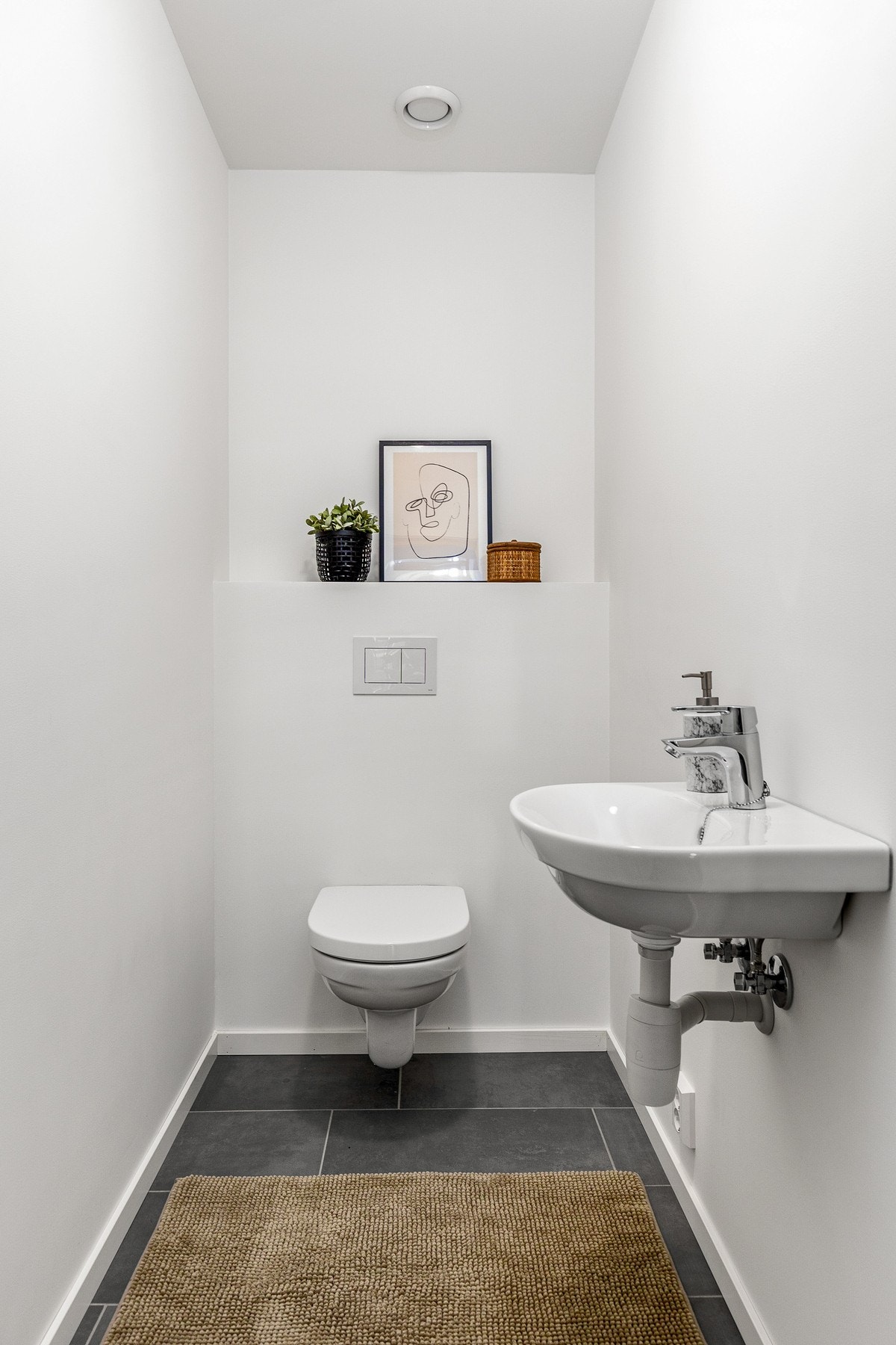 I første etasje ligger et praktisk gjestetoalett med fliser, toalett og servant. Det er avtrekk via balanserte ventilasjon. Galleribilde