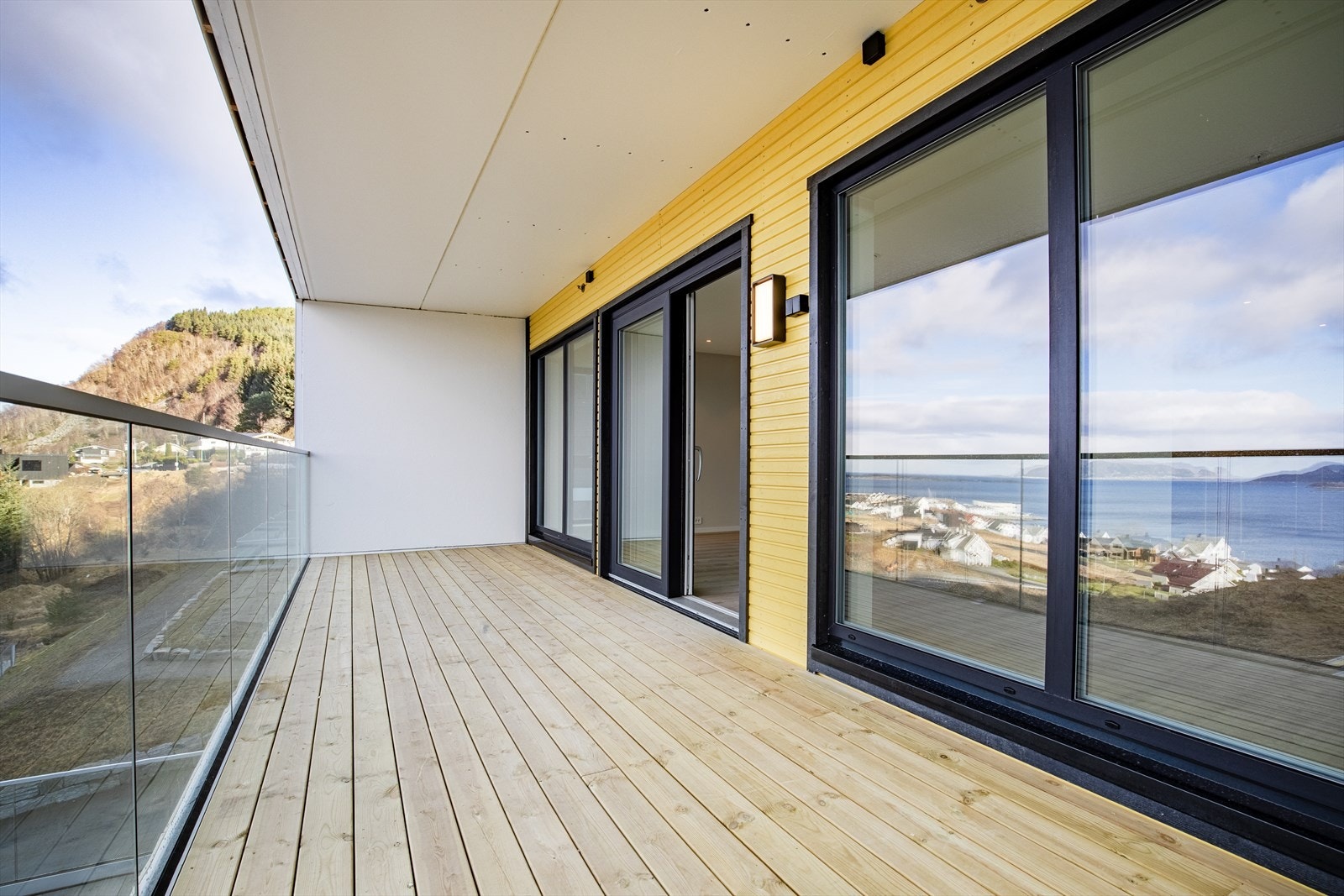 Stor veranda med takoverbygg og glassrekkverk Galleribilde