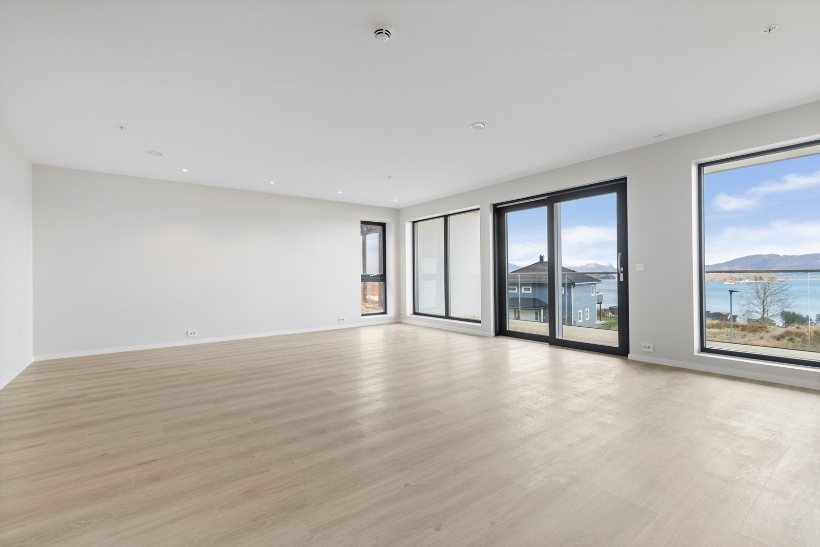 Romslig stue/kjøkken med store vindusflater, slette flater, spotter i tak og vannboren varme Galleribilde