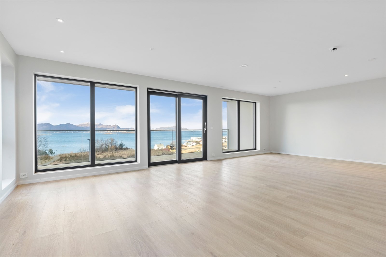 Romslig stue/kjøkken med store vindusflater, slette flater, spotter i tak og vannboren varme Galleribilde