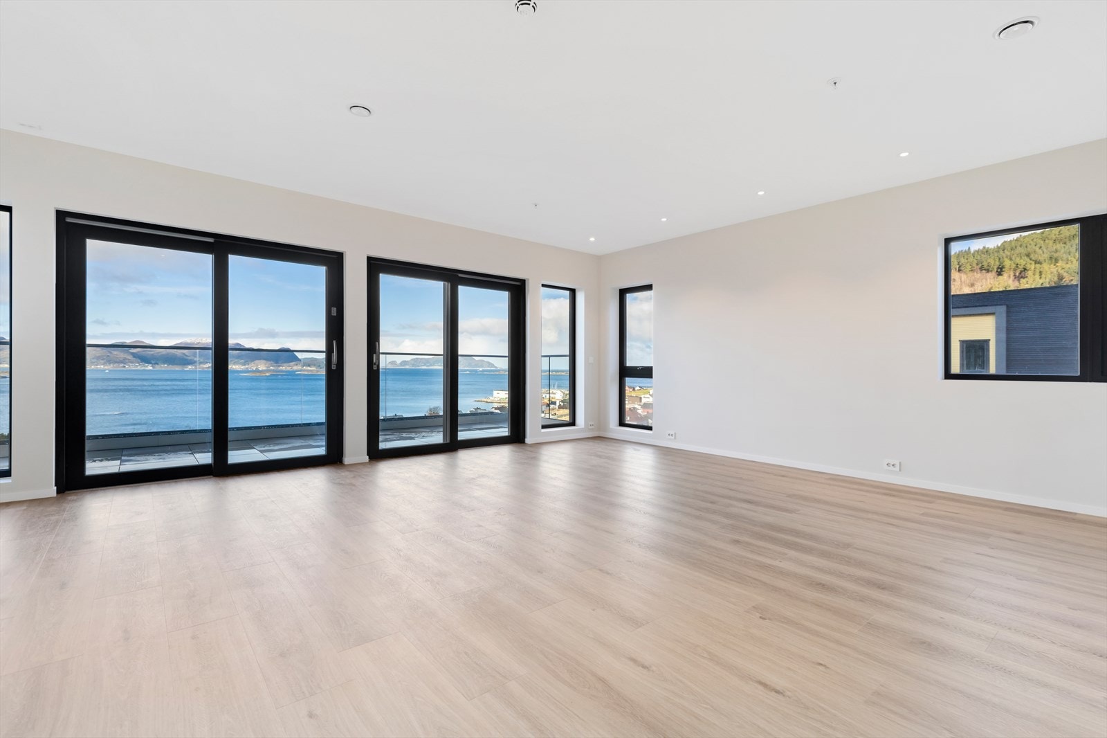 Romslig stue/kjøkken med ekstra takhøyde og store vindusflater. Stuen har to skyvedører mot veranda. Galleribilde