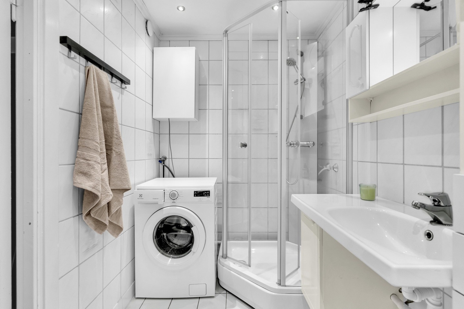 Flislagt baderom av eldre alder med gulvvarme og opplegg for vaskemaskin. Galleribilde