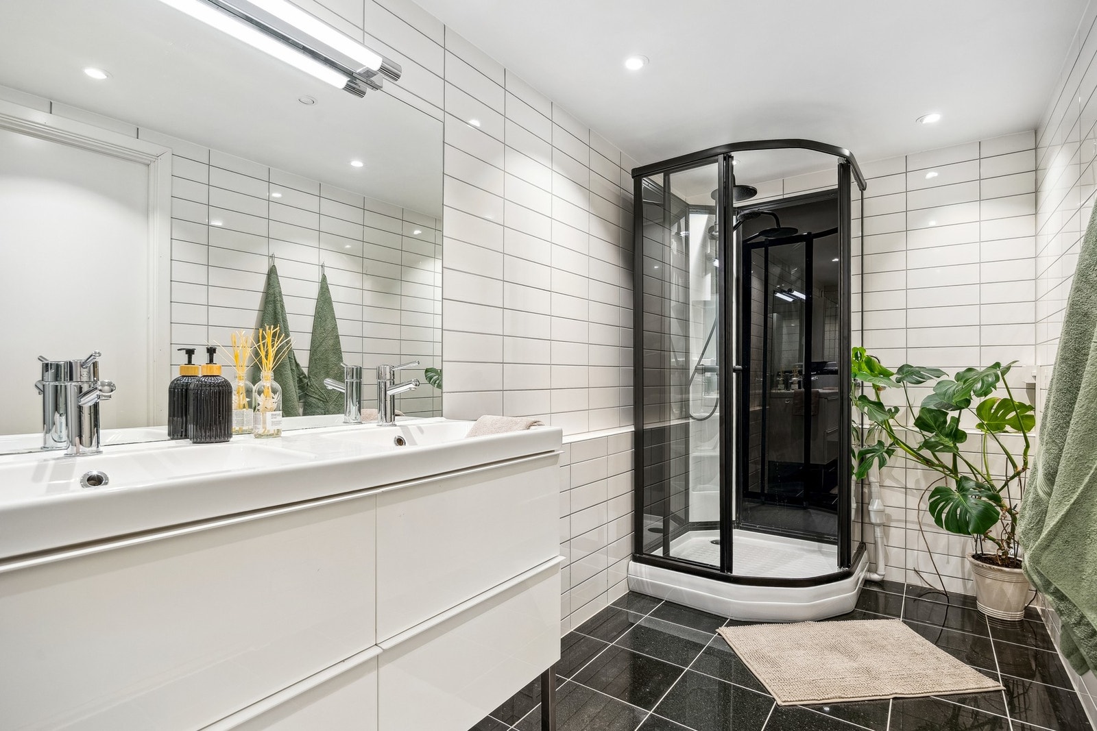 Pent flislagt baderom utstyrt med toalett, servantinnredning og dusjkabinett. Galleribilde