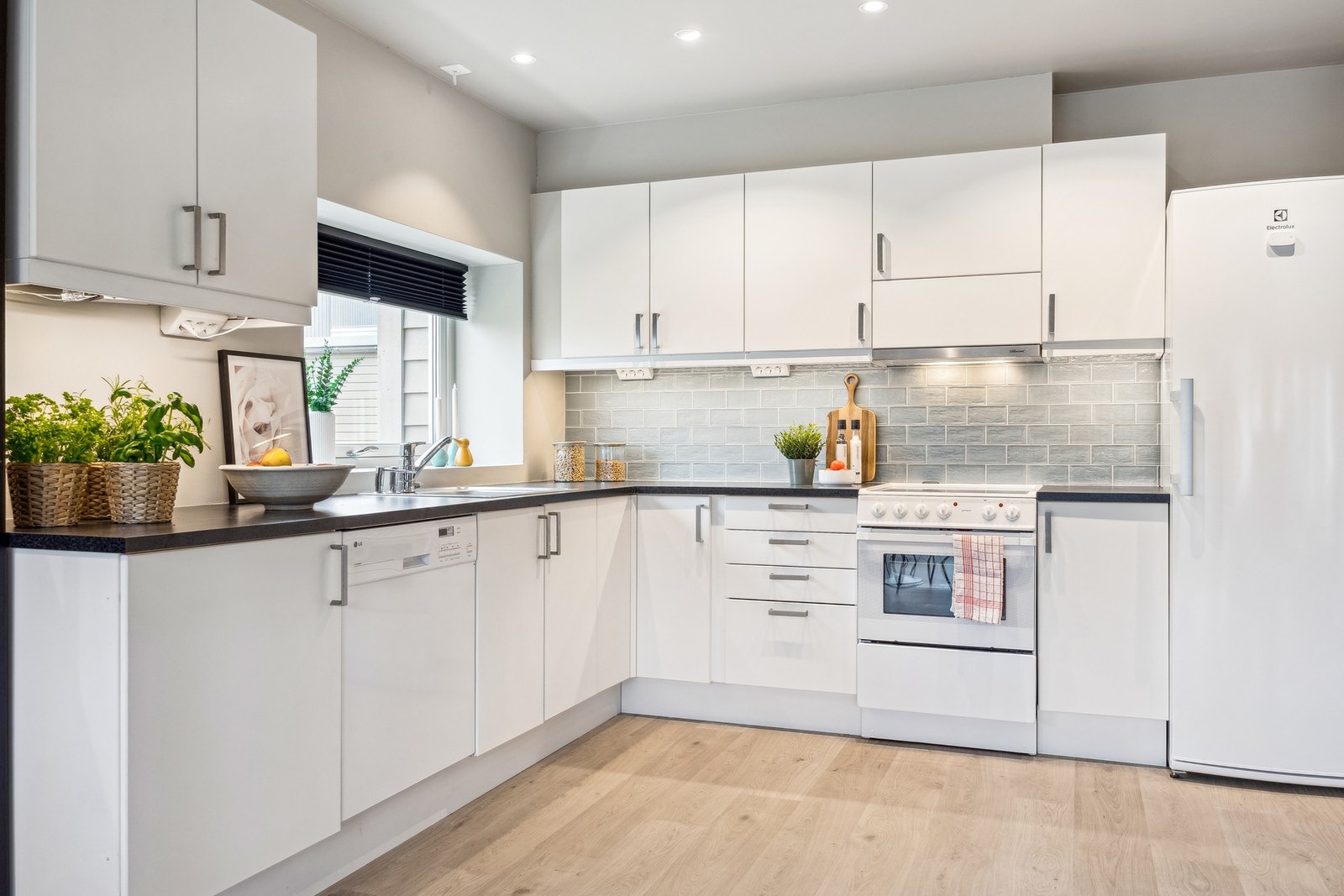 Kjøkkenet er utstyrt med frittstående komfyr, oppvaskmaskin og kjøleskap. Galleribilde