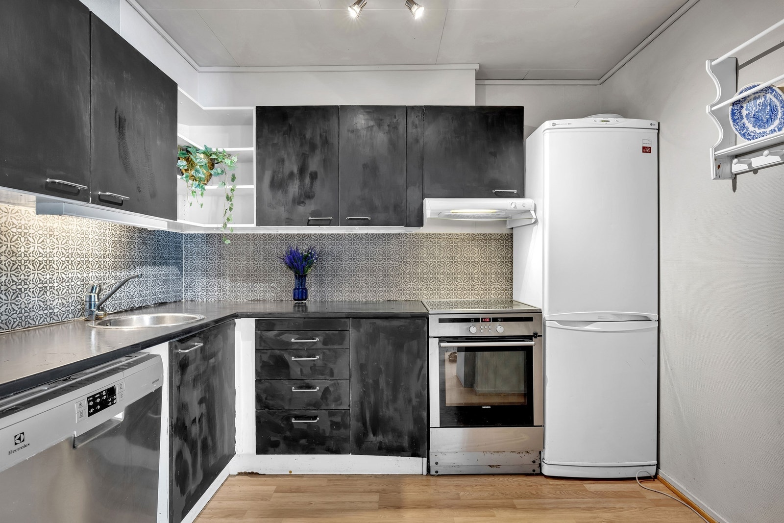 Det er utført i en L-form, som er svært praktisk i forhold til utnyttelsen av rommet. Kjøkkenet har svart, profilert innredning og heltre benkeplate. Galleribilde