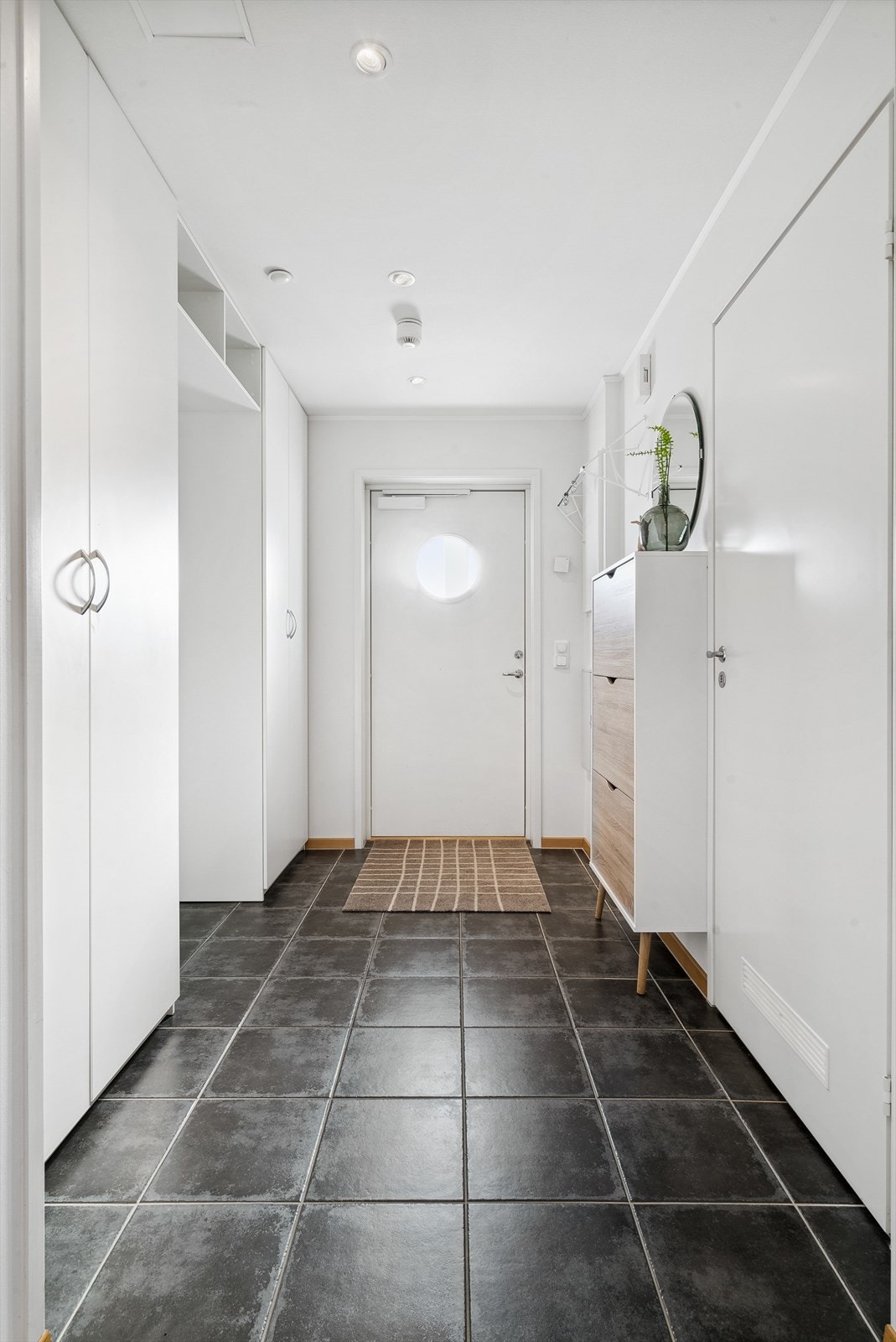 Leilighetens entré er flislagt og har som resten av leiligheten vannbåren varme i gulvet. I rommet er det to romslige garderobeskap samt skoskap, med andre ord gode oppbevaringsmuligheter for tøy og sko. Galleribilde