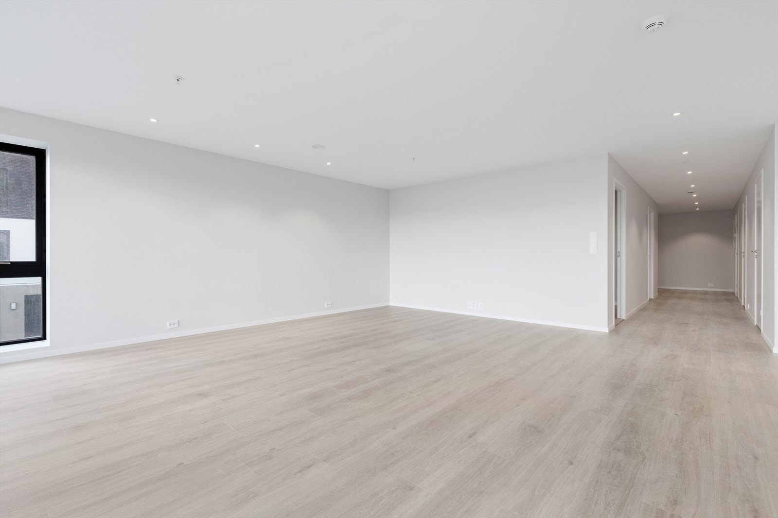 Lys om moderne leilighet med vannboren varme i gulv, spotter i himling og ellers slette, lyse flater. Galleribilde