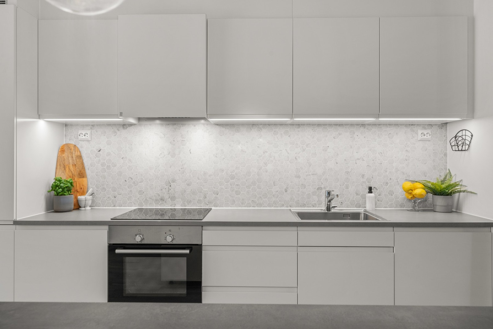 Frontene er hvite og håndtaksløse, og overskapene er foret til himling for et sømløst preg. Videre kan kjøkkenet skilte med Røroshetta avtrekksvifte Galleribilde