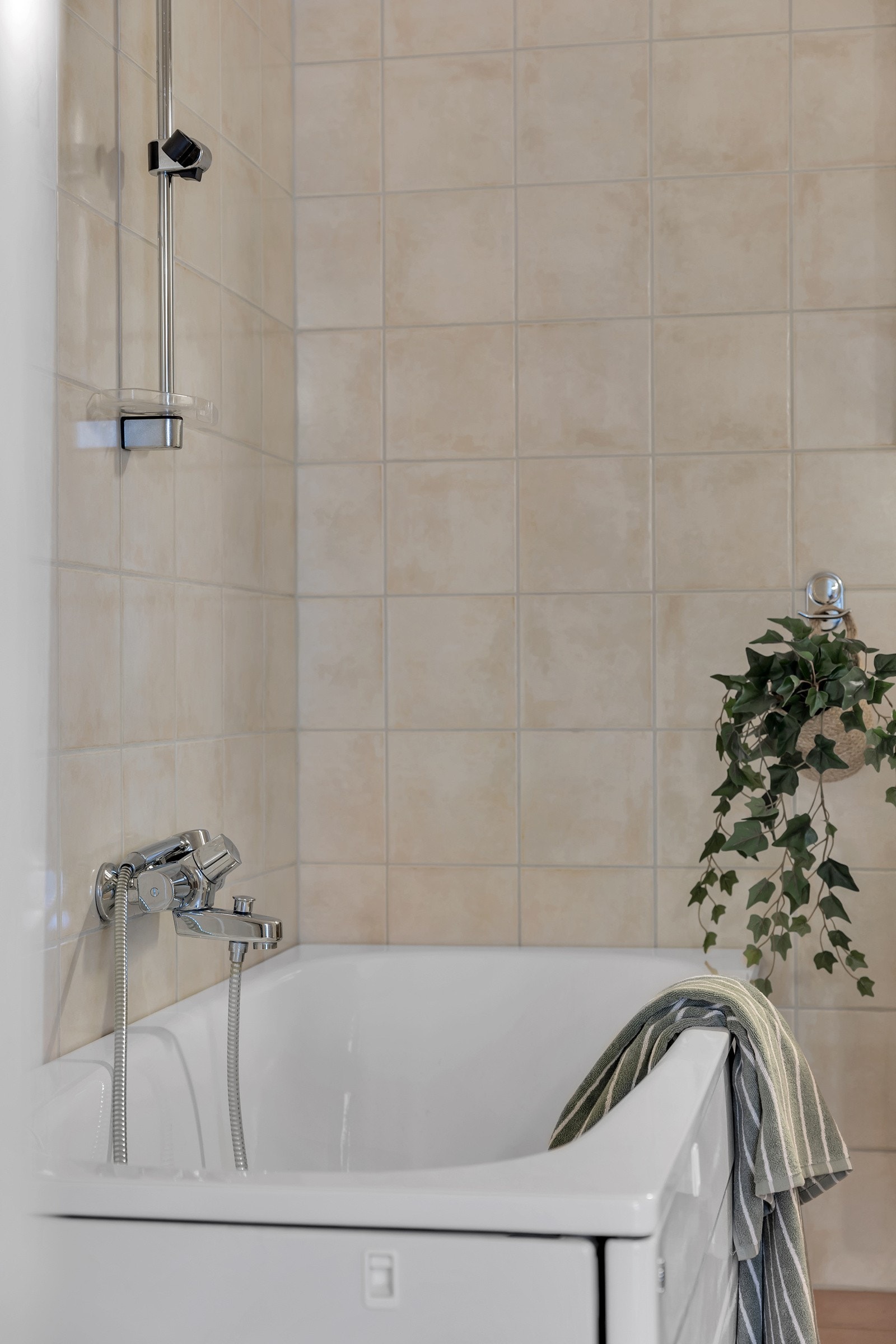 Gulv og vegger er flislagte og du har både badekar og dusjkabinett Galleribilde