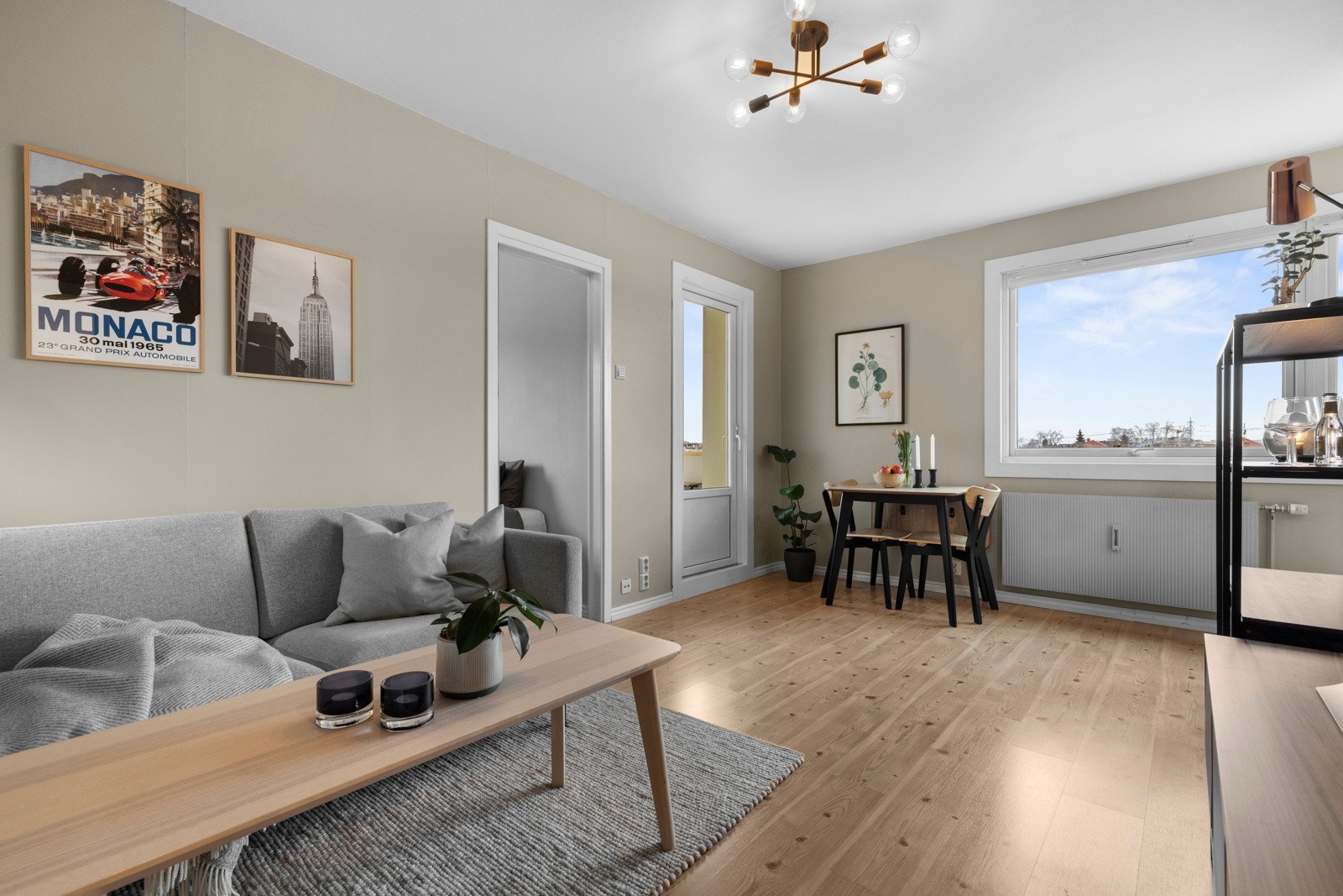 Leiligheten har en meget pen stue med lys laminat på gulv og harmonisk farge på vegger Galleribilde