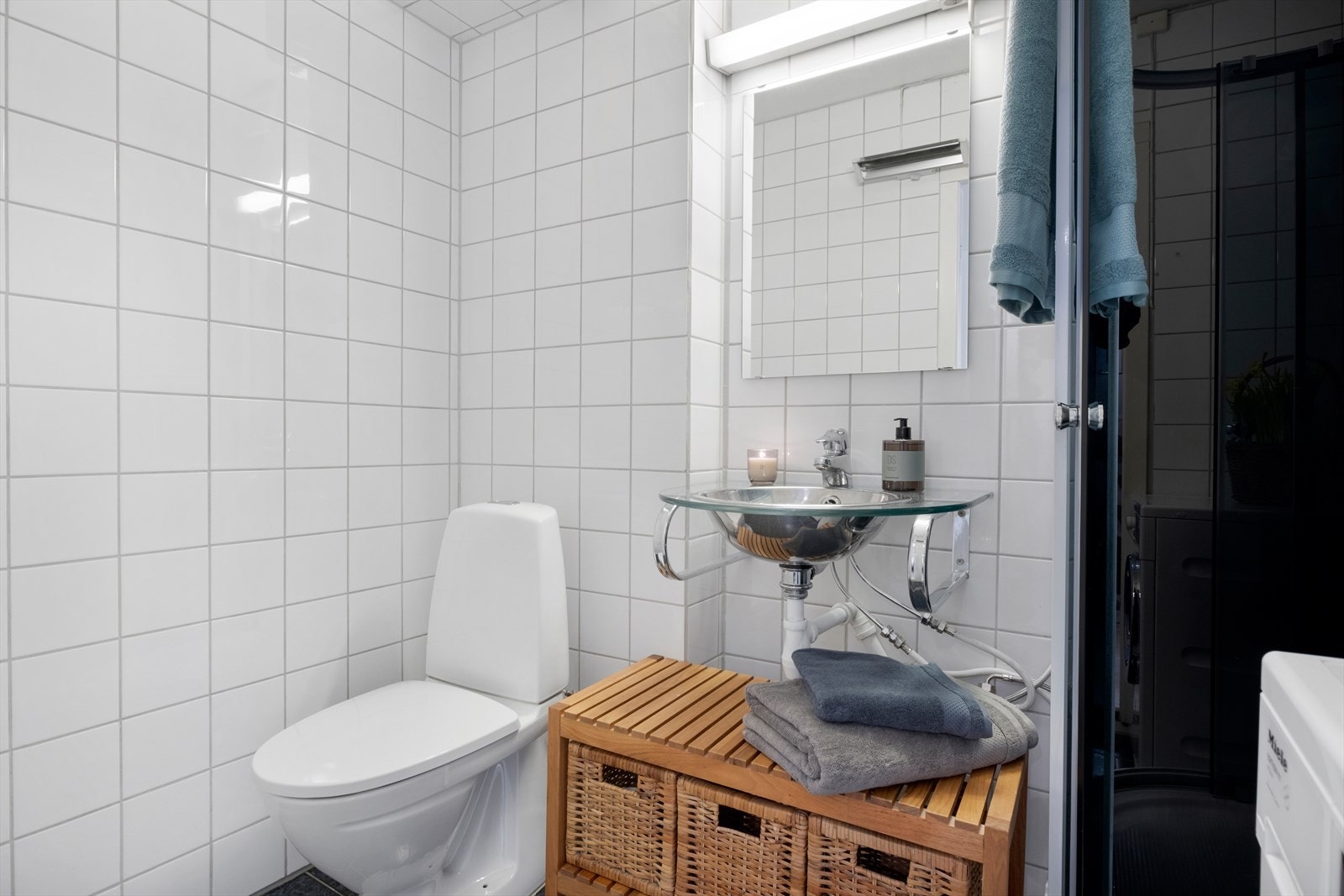 Pent flislagt bad i tilknytning til gang. Badet ble pusset opp i 2003, samt nytt toalett i 2013 og nytt dusjkabinett i 2024. Badet er innredet med dusjkabinett, toalett, opplegg for vaskemaskin (Kran og avløp), vegghengt servant. Galleribilde