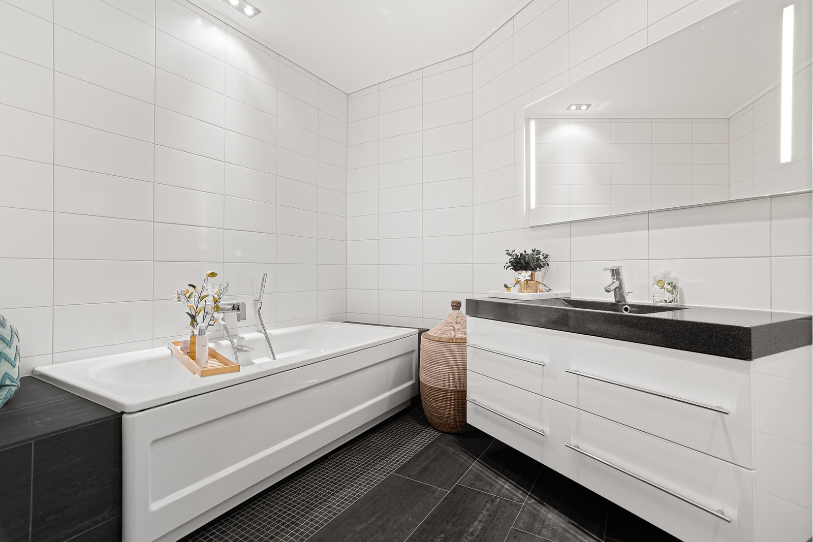 Bad i forbindelse med master bedroom i hovedetasje er innredet med badekar, toalett og baderomsinnredning med servant. Galleribilde