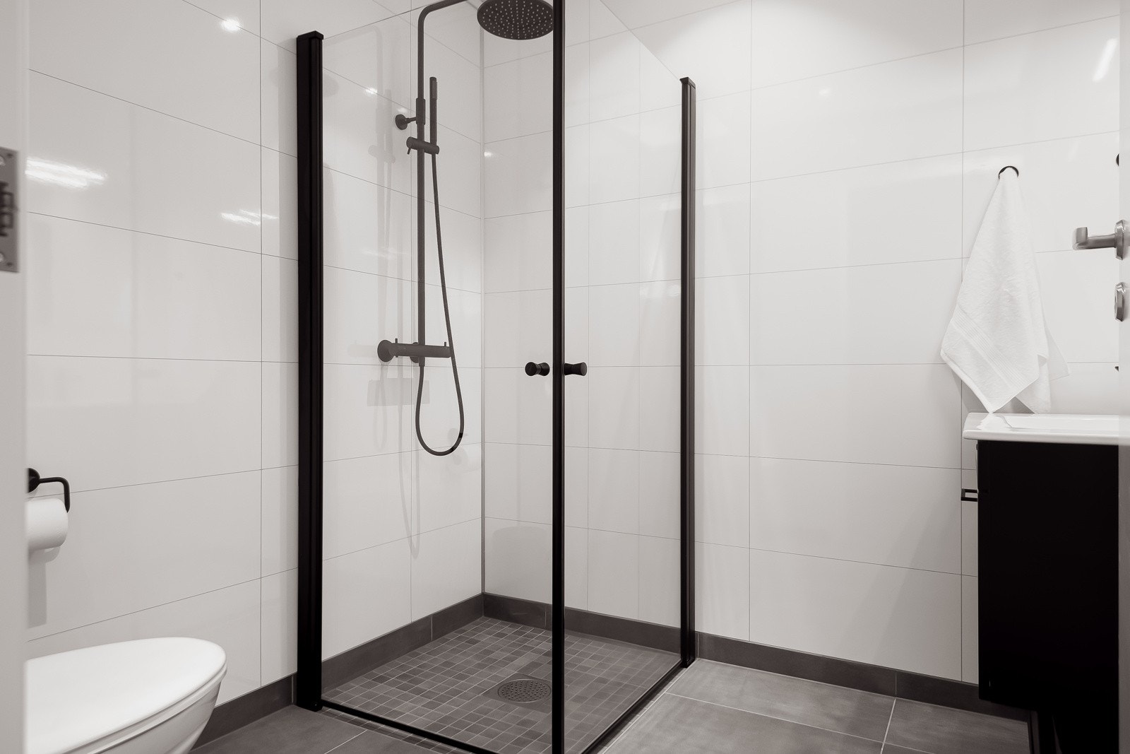 Bad også i 1. etasje med flislagt gulv med gulvvarme. Badet består av dusj med innfellbare dusjdører, vegghengt WC og innredning med servant. Galleribilde