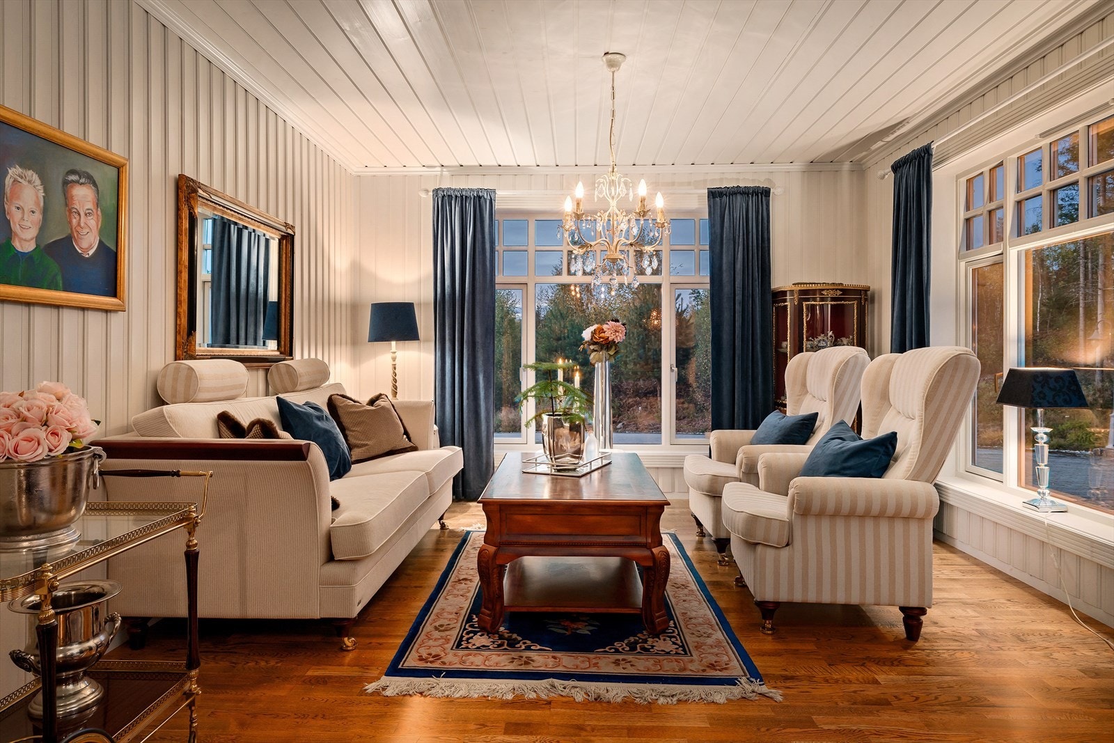 Kveldsstemningen i stuen skaper en lun og sofistikert atmosfære, perfekt for avslapning og hygge. Galleribilde