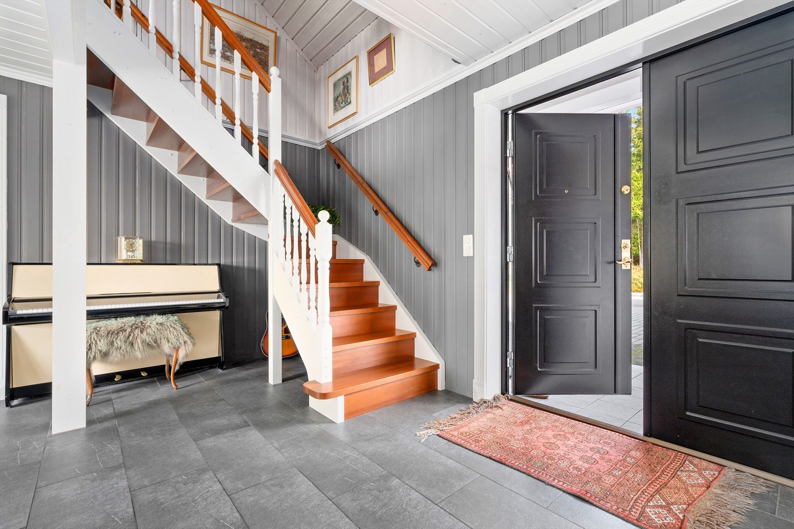 Flislagt, innbydende hall med god plass til oppbevaring av klær og sko i innebygd nisje og garderobeløsning. Galleribilde
