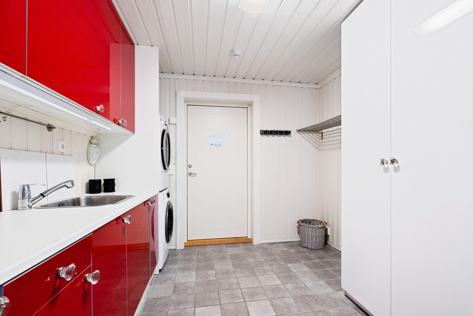 Praktisk innredet vaskerom i 1.etasje med en romslig innredning med over- og underskap og vask. Rommet har opplegg for vaskemaskin og tørketrommel. Galleribilde