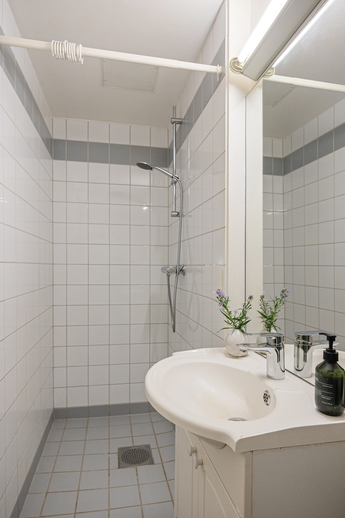 Badet inneholder dusjhjørne, servant med innredning, speil og toalett. Galleribilde