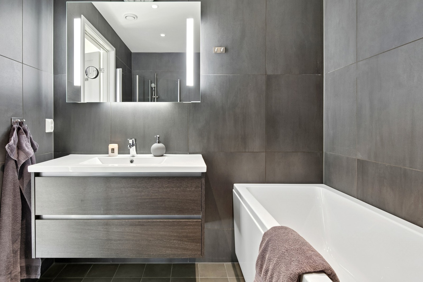 Badet er fullt flislagt med stilrene fliser og elektrisk gulvvarme. Galleribilde