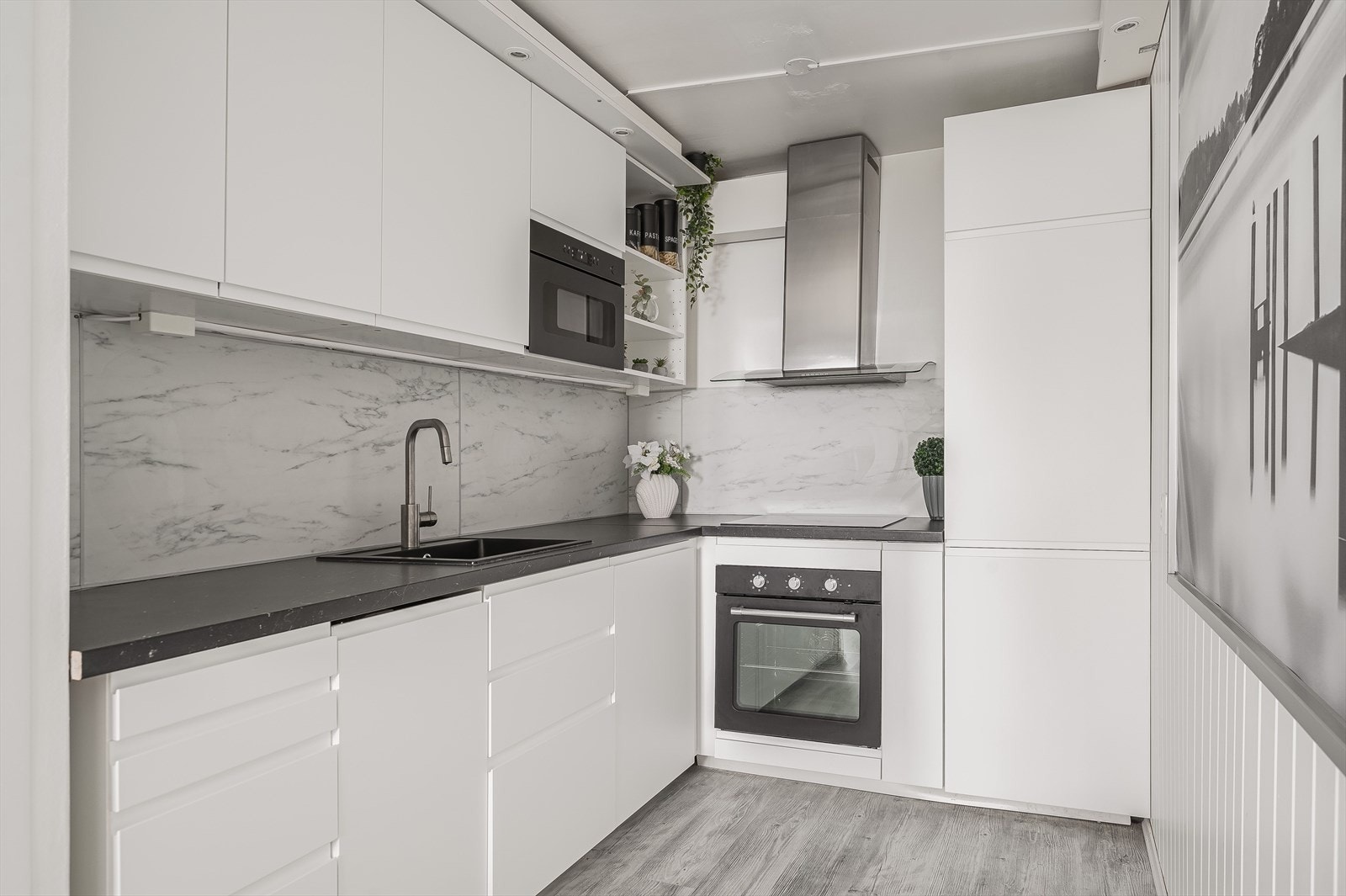 Moderne kjøkkeninnredning fra 2018 med god skap- og benkeplass. Innredningen har hvite glatte fronter og laminert benkeplate med nedfelt oppvaskkum. Galleribilde