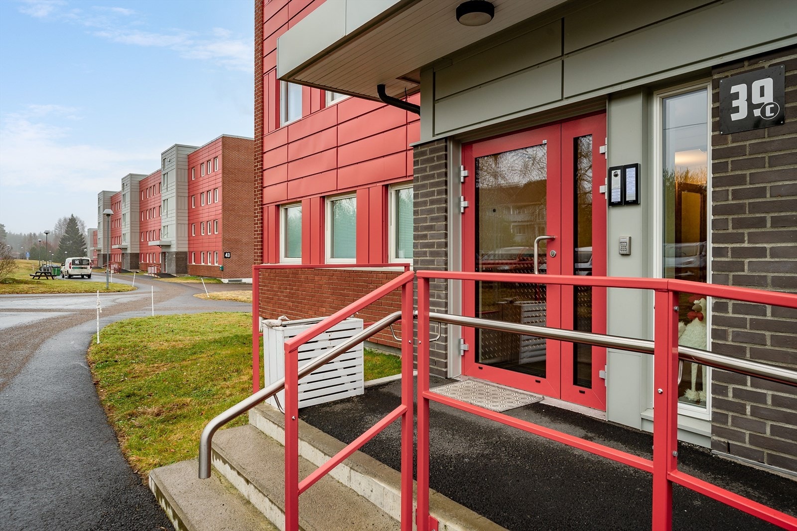 Overbygget inngangsparti inn til felles trapperom med heis opp til leiligheten som ligger i byggets toppetasje (4. etasje). Galleribilde