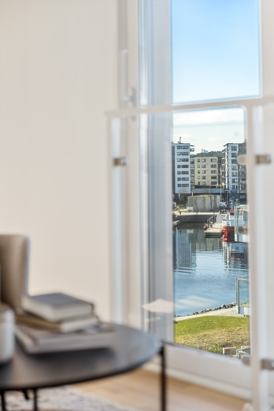 Man bor i maritime omgivelser og får noe utsikt over parkareal og kanalen inn mot brannstasjonen. Galleribilde