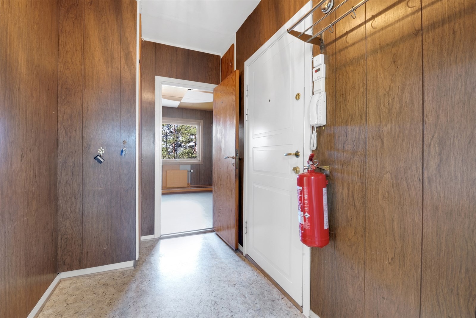 Entré med belegg på gulv, tynnpanel på vegger og malt tak. Galleribilde