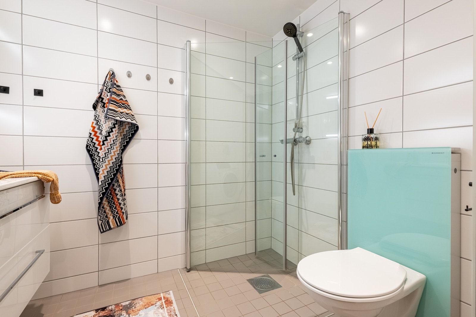 På badet er det baderomsinnredning med to skuffer med nedfelt servant, speil, vegghengt toalett og dusjvegger/hjørne. Galleribilde