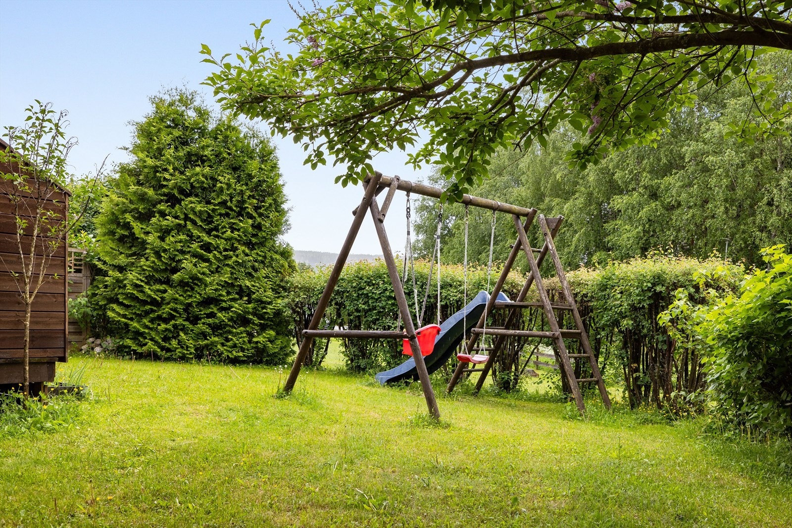 Hagen har hekk mot fellesareal, prydbusker og gressplen. En skjermet og koselig hagedel med plass for hagemøbler og lekeapparat. Galleribilde