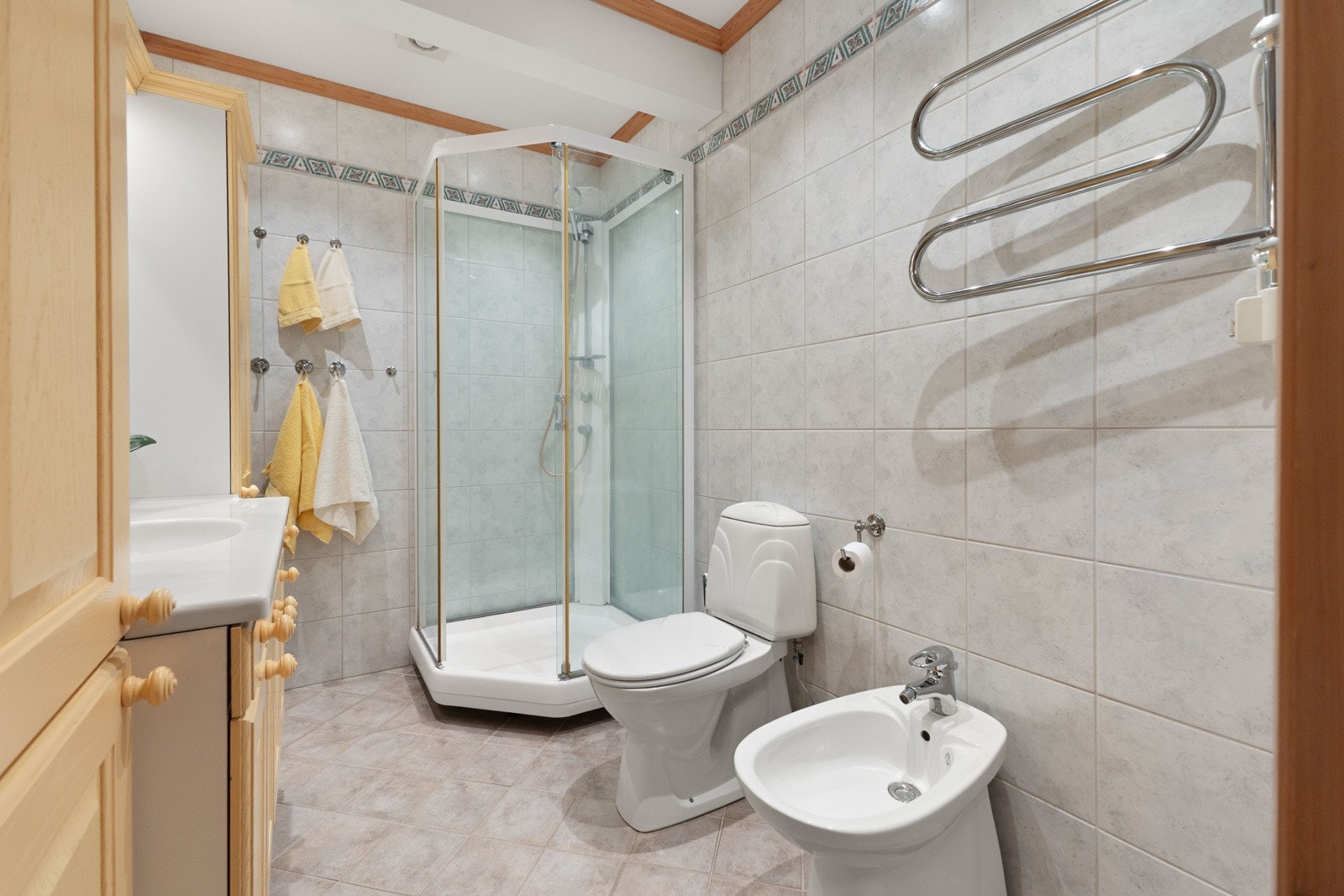 Badet har dusjkabinett, toalett, bidet, og servant med skap Galleribilde