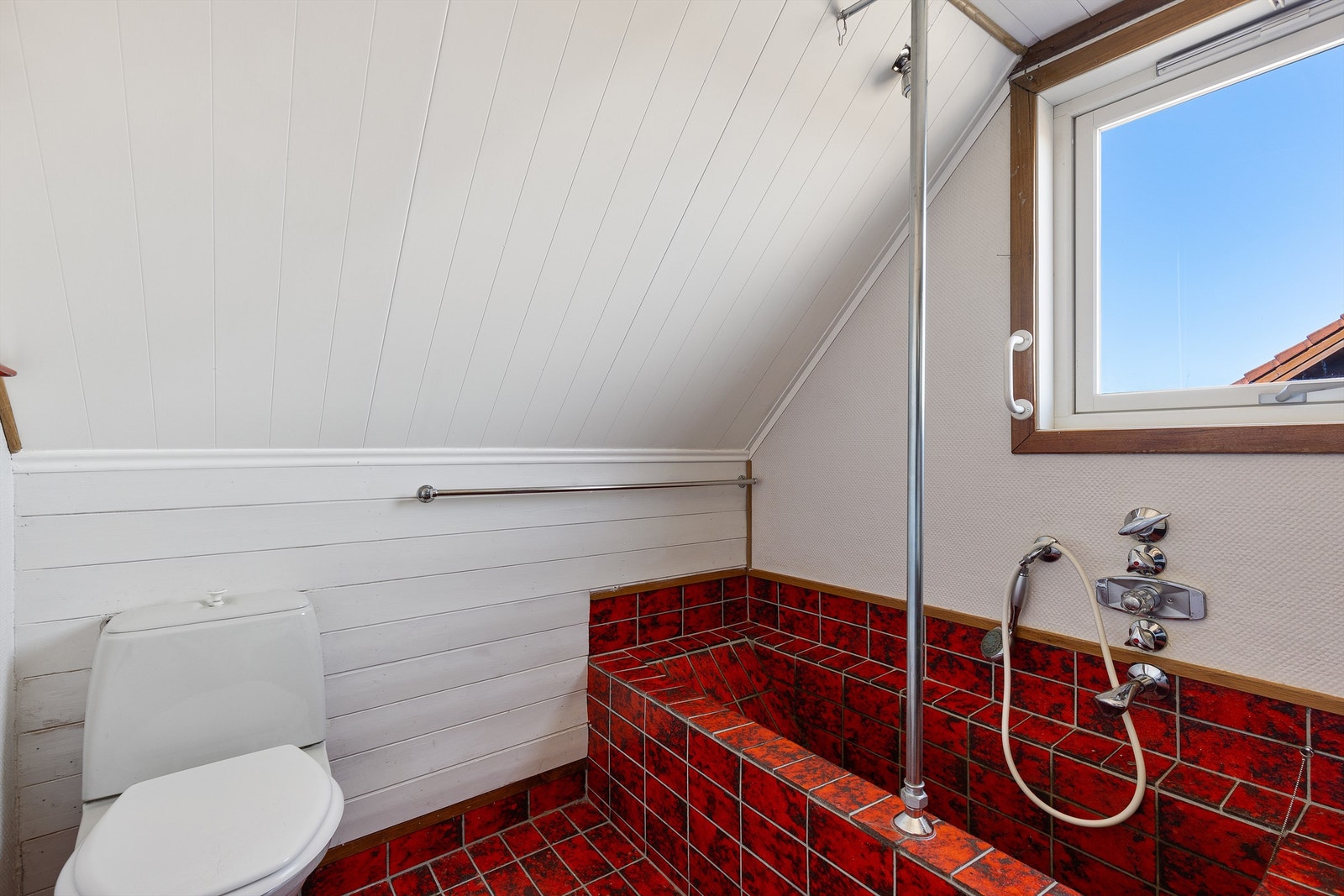 Badet er flislagt med flislagt badekar. Galleribilde