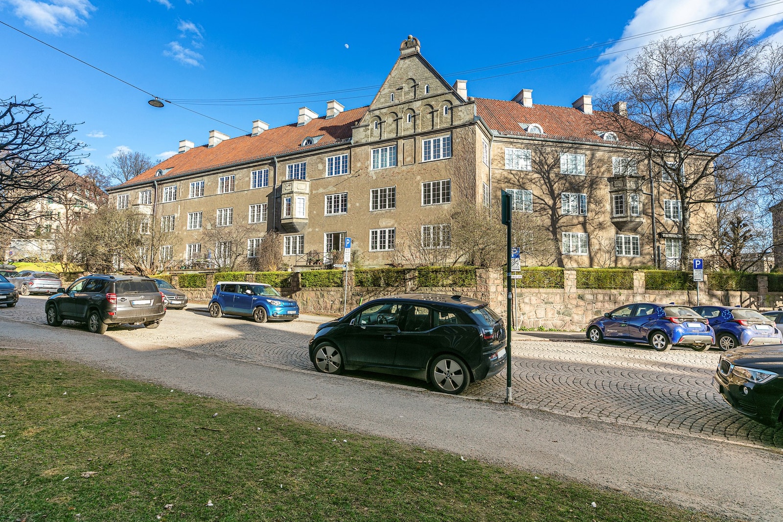 Gatene er brosteinsbelagte og rammet inn av høye trær Galleribilde