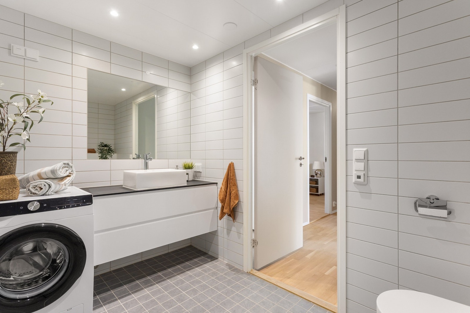 Dette badet er utstyrt med innredning med to store skuffer og servant, veggmontert toalett og dusjvegger/hjørne. Galleribilde