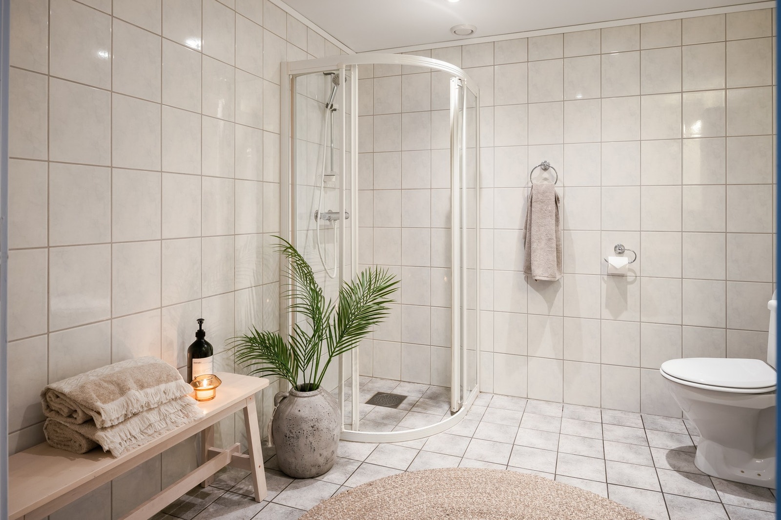 Delikat baderom med lyse fliser, separat dusjhjørne og god plass. Galleribilde