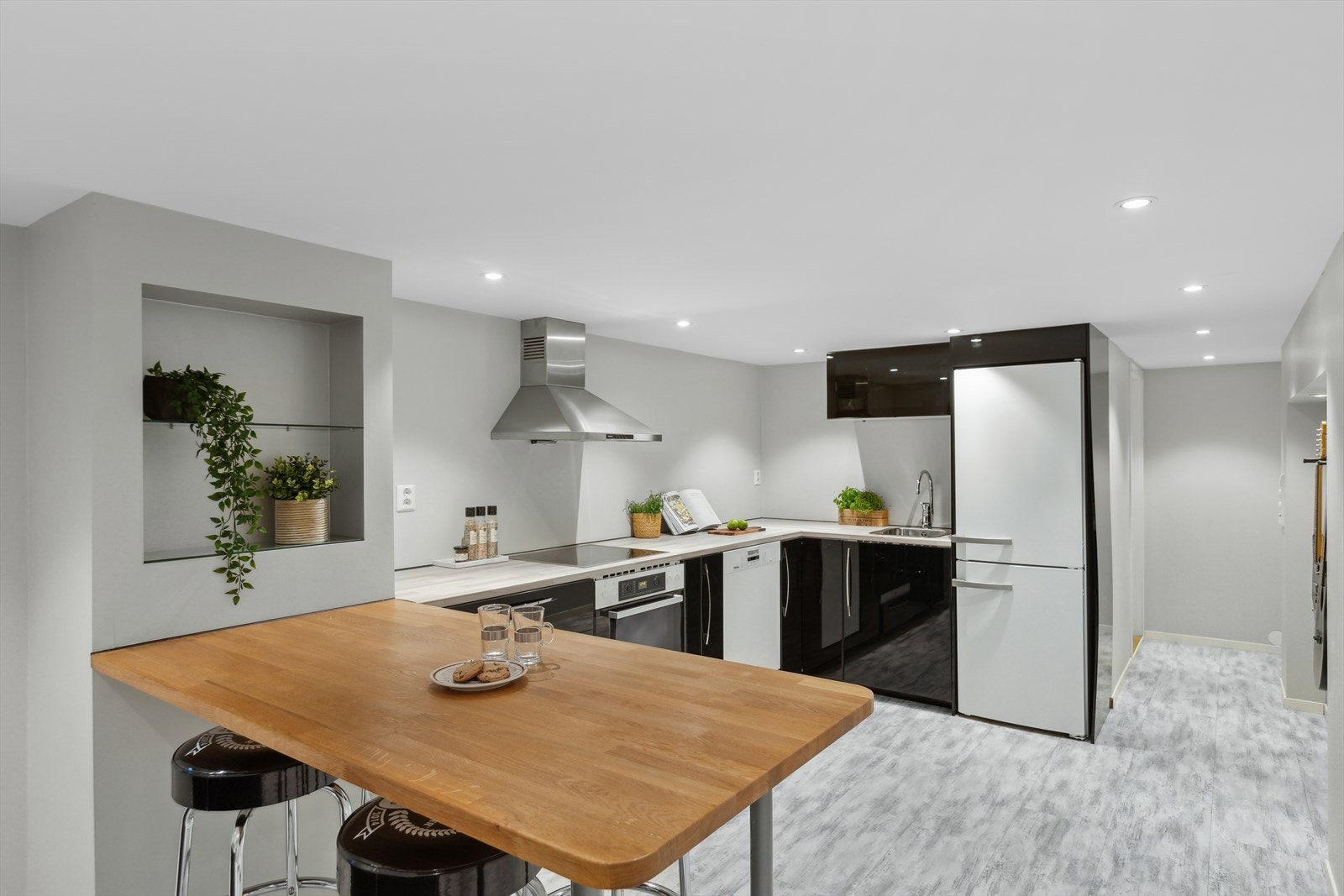 Kjøkkeninnredning med folierte skrog, slette fronter og laminert benkeplate. Malt gips på vegg over benkeplate. Galleribilde